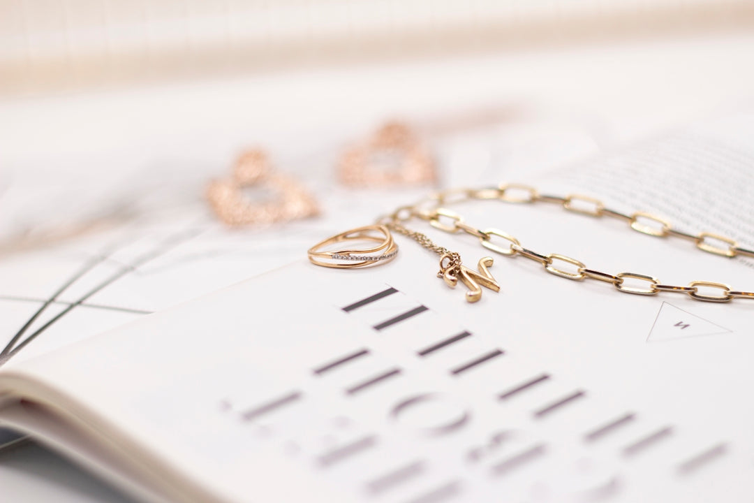 gold necklace on white paper