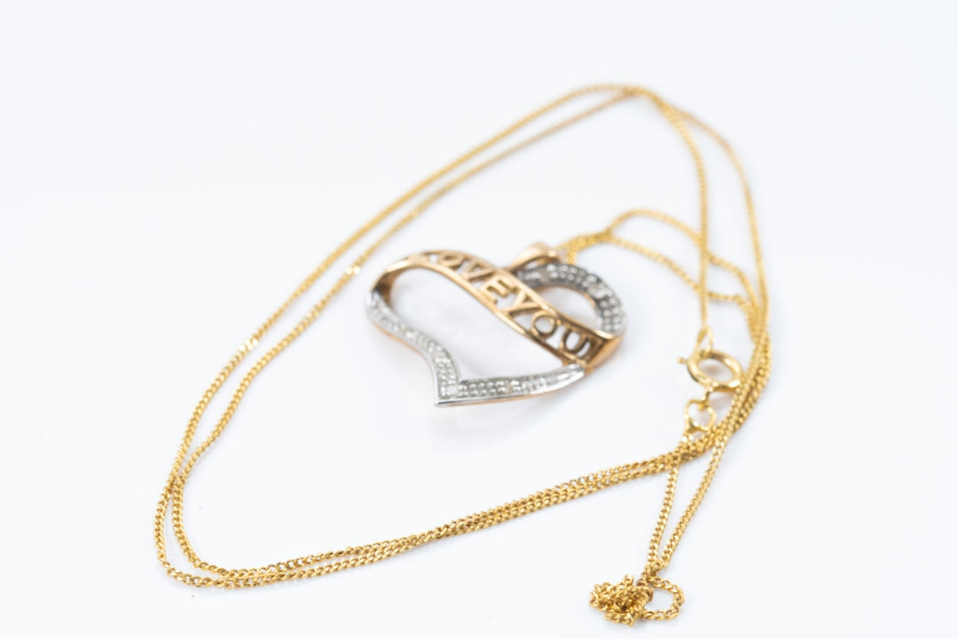 a gold necklace with a heart shaped pendant