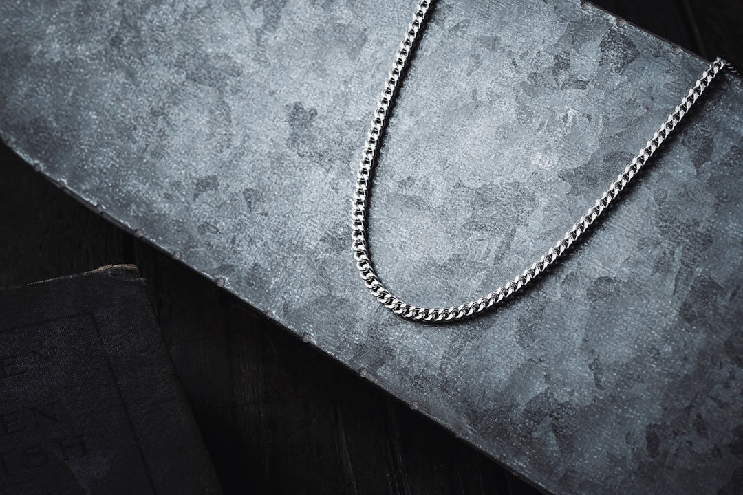 a silver chain laying on top of a table