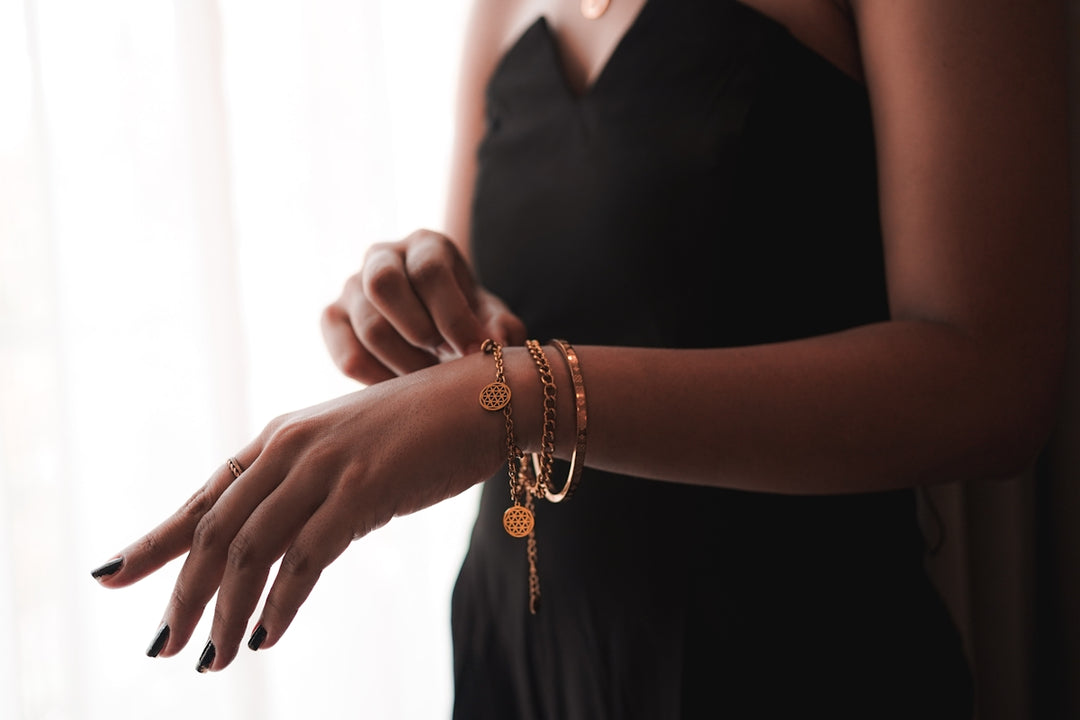 A woman in a black dress holding onto a bracelet